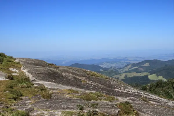 "Vista das montanhas de Monte Verde, MG, com céu azul e vales da Serra da Mantiqueira"
