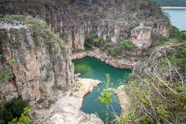 “Cânion de Capitólio, MG, com paredões rochosos e água verde-esmeralda vista de mirante natural.”