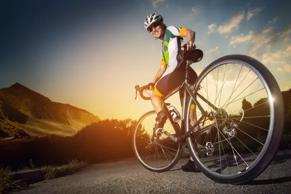 “Cicloturista em estrada iluminada pelo pôr do sol, cenário típico de viagens de bike por Minas Gerais.”