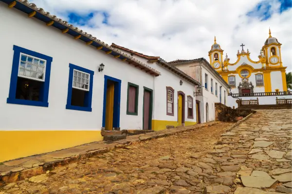 “Casario colonial com fachadas coloridas em rua de pedra no centro histórico de Tiradentes, Minas Gerais.”
