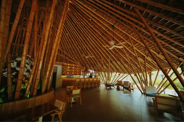 “Interior de pousada com arquitetura ecológica em bambu, estrutura sustentável e design contemporâneo em Minas Gerais.”
