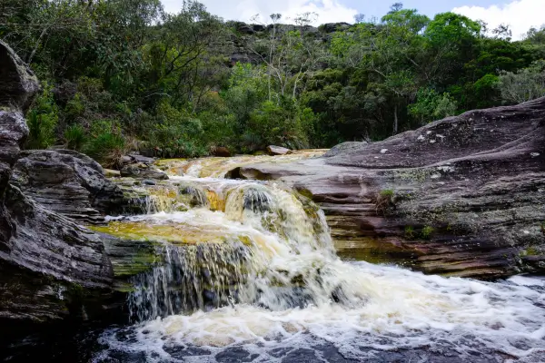 “Pequena cachoeira de águas cristalinas correndo por rochas na Serra da Mantiqueira, em Liberdade, Minas Gerais.”