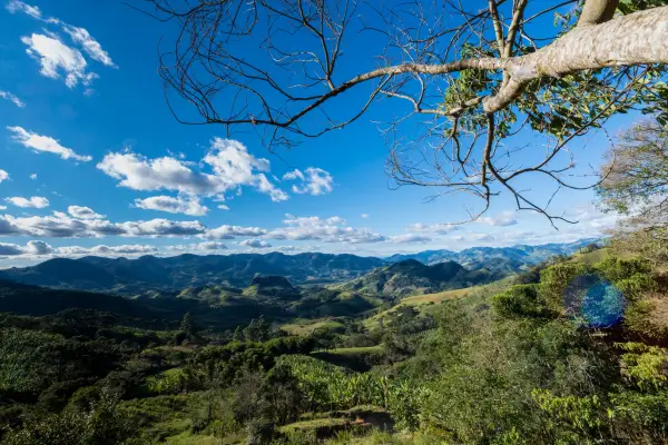 “Vista panorâmica das montanhas de Gonçalves, MG, com vales verdes e céu azul na Serra da Mantiqueira.”