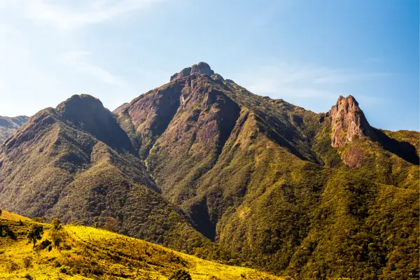 “Montanhas da Serra da Mantiqueira em Camanducaia, Minas Gerais, com picos verdes iluminados pelo sol.”