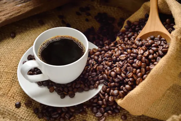 Café em xícara com grãos